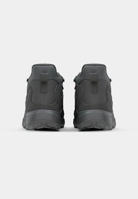 Black athletic shoes with a textured surface, featuring gray accents and a durable outsole. Rear view shows padded collar and pull tabs.