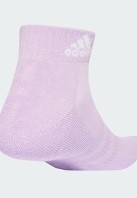 Πορτοκαλί καλτσάκι αστραγάλου από πλεκτό ύφασμα, με ριμπ μανσέτα και λευκό λογότυπο Adidas. Απλός σχεδιασμός για άνετη εφαρμογή.