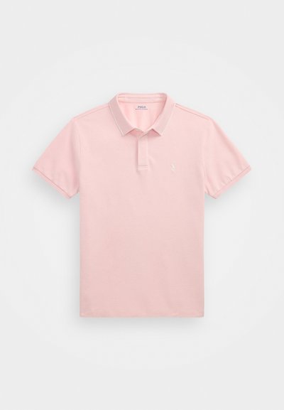 Šviesiai rožinė polo marškinėliai, pagaminti iš medvilnės, su trumpomis rankovėmis, smailiu apykakle ir maža išsiuvinėta logotipu krūtinėje.