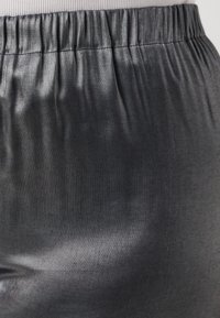 Lightweight black satin pants with an elastic waistband, smooth texture, and a subtle sheen, showcasing a sleek and fitted design.