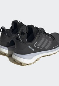 Sorte joggesko i svart med strukturert mesh-overdel, grå accenter og hvit skummiddelsåle. Har tre-stripes design og robust yttersåle.