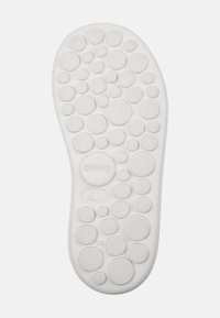 White rubber shoe outsole featuring a circular, textured surface with varying sizes of circular patterns and the "Camper" logo.