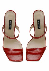Red patent leather sandals with a square toe, dual straps across the foot, and a slingback design. Features a cushioned insole.