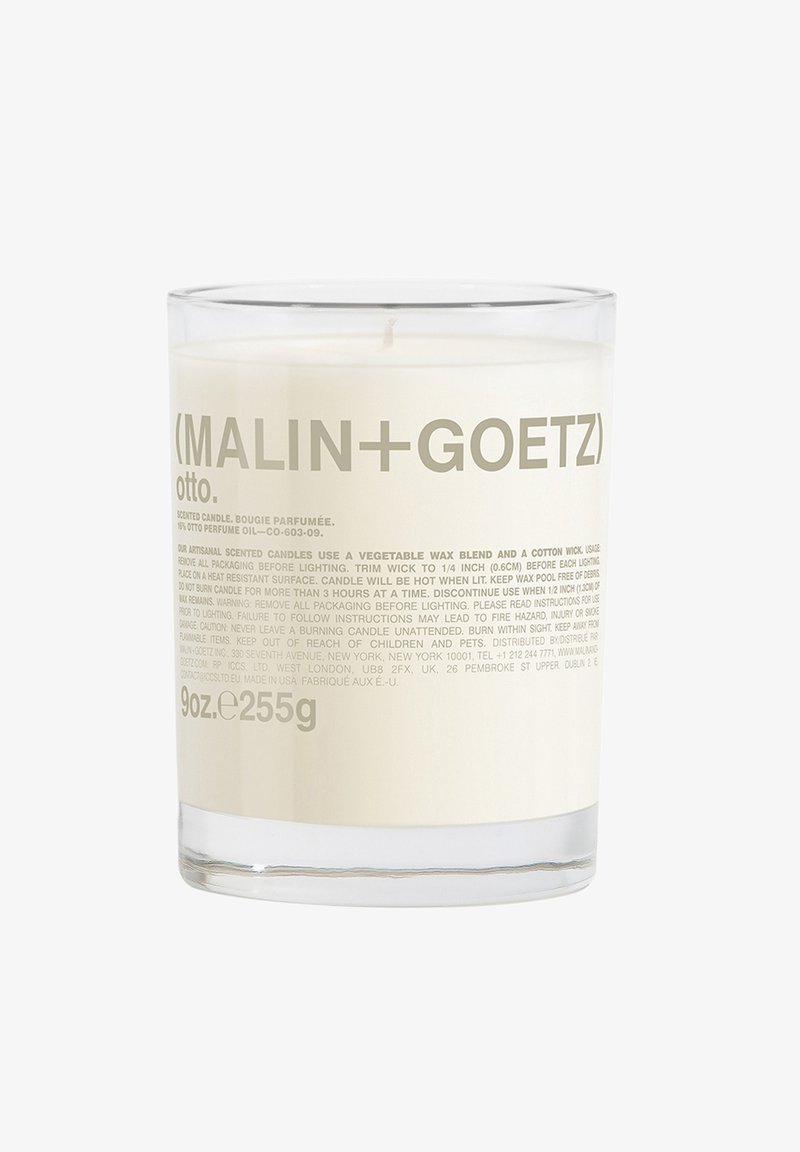 Duftkerze in einem klaren Glasbehälter. Weißes Wachs sichtbar mit einem Baumwolldocht. Das Etikett zeigt grauen Text mit Produktdetails und Branding.