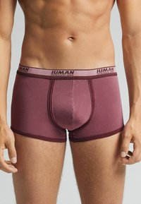 Boxer briefs burdeos fabricados en tejido elástico, con una cinturilla elástica que presenta una marca en contraste y un diseño ajustado.