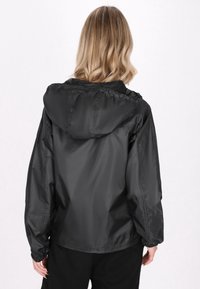 Giacca a vento nera con cappuccio, polsini elasticizzati e vestibilità morbida. Realizzata in materiale leggero con una texture liscia.