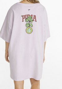 Lila übergroßes T-Shirt mit kurzen Ärmeln, mit einem grafischen Aufdruck "PUMA", einer grünen Pflanze und einem Globus-Design auf der Rückseite.