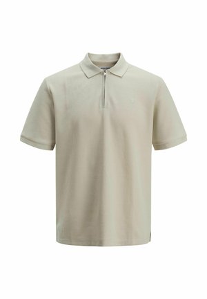 Polo shirt i lyse beige, kortermet, glidelås på brystet, strukturert stoff, subtilt logo på brystet, og sidesplitter i kanten.