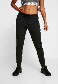 Schwarze Jogginghose aus weichem Material mit elastischem Bund und Kordelzug. Eng zulaufende Beine für einen snug fit.
