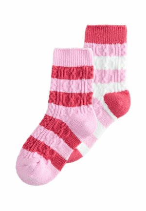 Ein Paar gestrickte Socken mit abwechselnden horizontalen Streifen in Pink, Rot und Weiß, die mit strukturierten Kabelstrickmustern versehen sind.