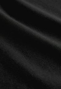 Fekete szövet sima textúrával, finom fényvisszaverődésekkel és lágyan lecsüngő formával, egyenletes, vékony fonalakkal.