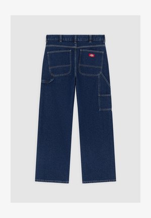 Donkerblauwe denim werkbroek met wijde pijpen, twee grote achterzakken, zijvak voor gereedschap en een rood merkembleem op de rechterachterzak.