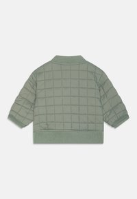 Veste bomber matelassée de couleur vert clair, avec un col et des poignets côtelés, un motif carré cousu et un ourlet élastique.