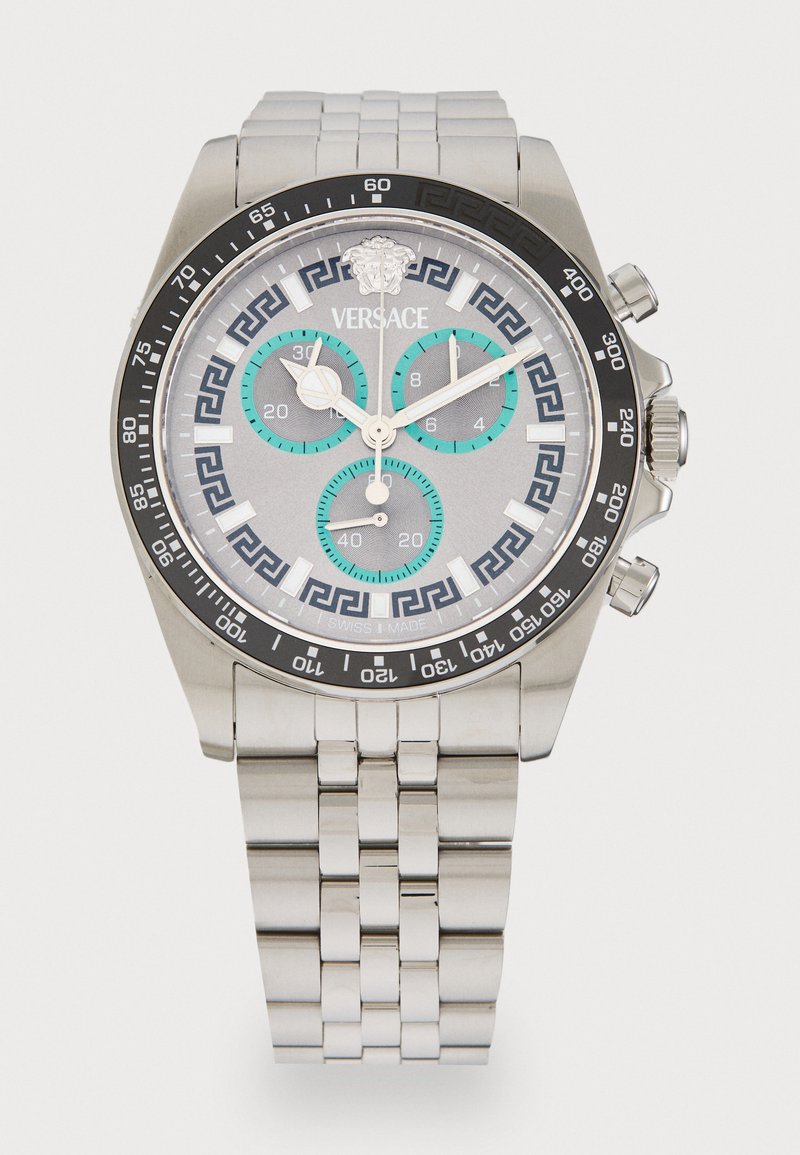Silver stainless steel watch with a gray dial, black bezel, turquoise accents, and Greek key pattern. Features chronograph subdials and logo.