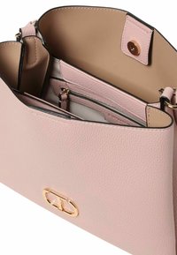 Lichtroze leren handtas met een gestructureerde afwerking, voorzien van gouden logo-hardware en een bicolor interieur met meerdere compartimenten.