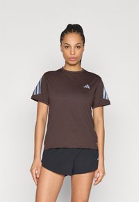 Brązowa sportowa koszulka z niebieskimi paskami na rękawach i logo na piersi; krótkie rękawy, okrągły dekolt, wykonana z lekkiego, gładkiego materiału.