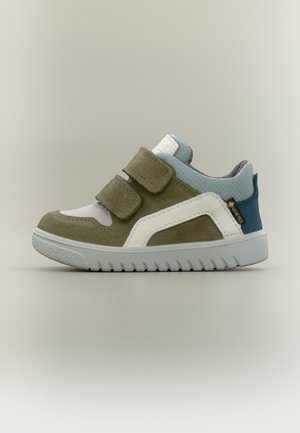 Baskets pour enfants en daim vert olive, bordure blanche, talon en tissu bleu, semelle grise et deux brides velcro, montrées de profil sur fond uni.