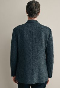 Szary marynarka w tweed, teksturowany materiał, strukturalny design, pojedynczy tylni wentyl, klapy typu notch, dwa guziki na mankietach, skomponowana w stylu prostym.