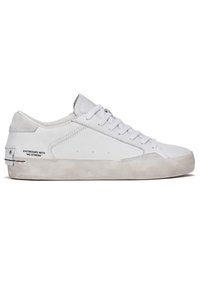 Witte sneaker van leer en suède, met een laag profielontwerp, ronde neus, platte veters en een gestructureerde rubberen zool.