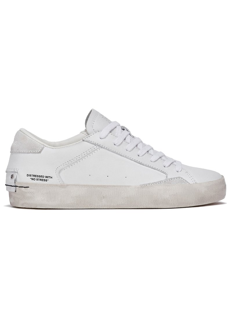 Witte sneaker van leer en suède, met een laag profielontwerp, ronde neus, platte veters en een gestructureerde rubberen zool.