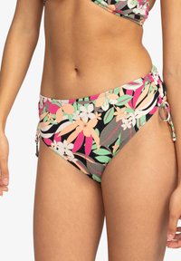 Flerfärgad bikiniunderdel med ett blommönster i rosa, grönt och vitt på en svart bakgrund. Sidoknytningar med kontrasterande beslag.