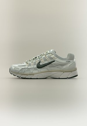 Baskets Nike P-6000 gris clair avec logo swoosh noir et design texturé détaillé, présentées de côté sur un fond uni.