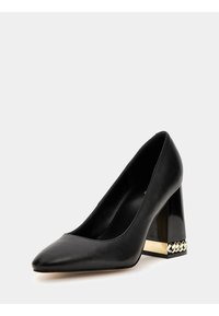 Escarpin noir en cuir à bout pointu avec un talon épais transparent, orné d'accents dorés et de chaînes à la base. Texture lisse, design épuré.