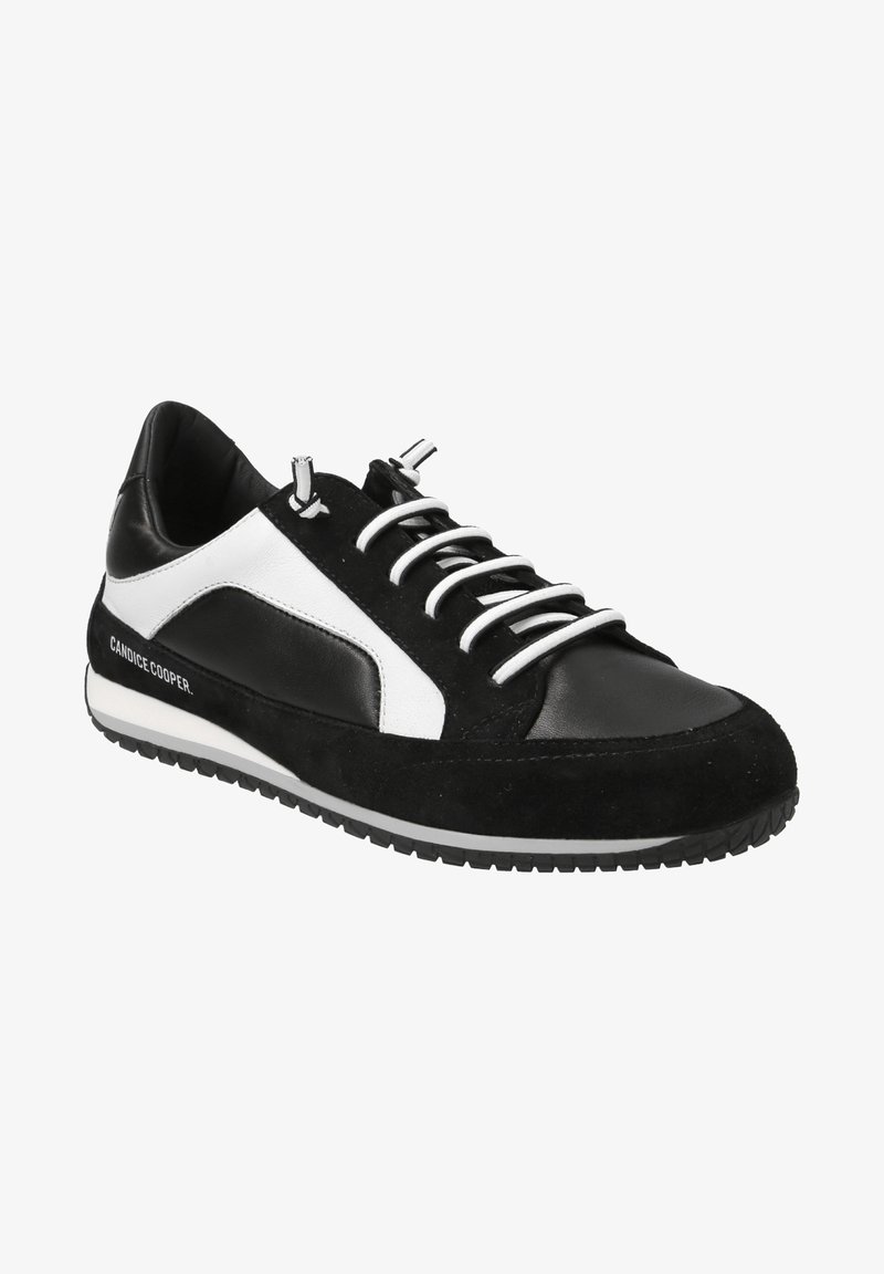 Une sneaker noir et blanc avec un mélange de cuir et de daim, dotée d'une semelle noire texturée, de lacets blancs et d'un logo sur le côté.