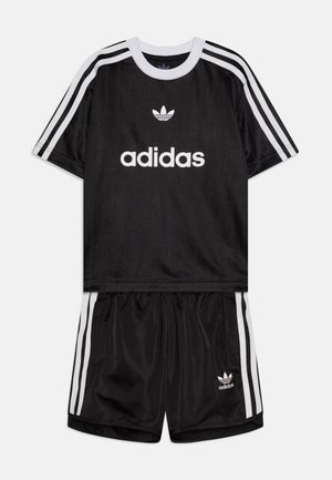Ensemble de sport noir composé d'un t-shirt à manches courtes avec des accents blancs et d'un short. Comprend le logo Adidas et trois bandes blanches sur les manches et les côtés.
