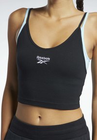 Fekete bordás crop top világoskék állítható pántokkal. Az elején hímzett "Reebok" logó található. Puha tapintású, testhezálló dizájn.