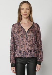 Langärmlige Bluse aus transparentem Stoff mit einem Paisleymuster in dunklen Tönen, ausgestattet mit einem Reißverschluss am Halsausschnitt und strukturierten schwarzen Ärmelbündchen.