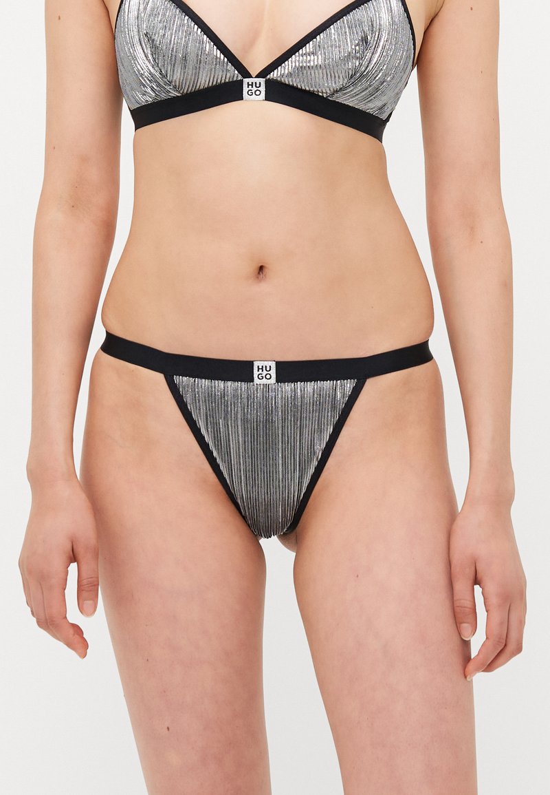 Metallinho hopeapintainen bikinitoppi, jossa on poimutettu rakenne ja musta reunus, jossa on brändätty merkki keskellä. Yhdistetty vastaavilla hopeapintaisilla thong-pohjilla.