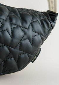 Fekete steppelt bőr pénztárca geometriai mintával és arany címkével. A dizájn texturált felületet és sima széleket tartalmaz.