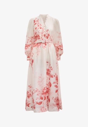 Longue robe crème avec motifs floraux roses, manches longues bouffantes, devant boutonné et ceinture assortie avec boucle ronde à la taille.