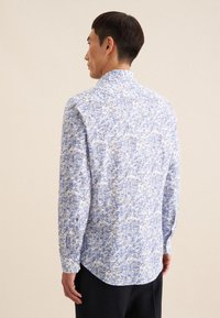 Langarmshirt in een blauw-witte bloemenpatroon, met een button-down kraag en een gebogen zoom. Lichtgewicht stof met een gladde textuur.