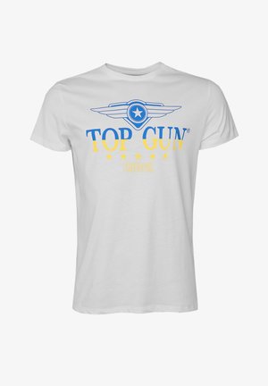 Witte katoenen t-shirt met een blauw en geel ontwerp met de tekst "TOP GUN" en "FREEDOM," omringd door vijf gele sterren. Korte mouwen.