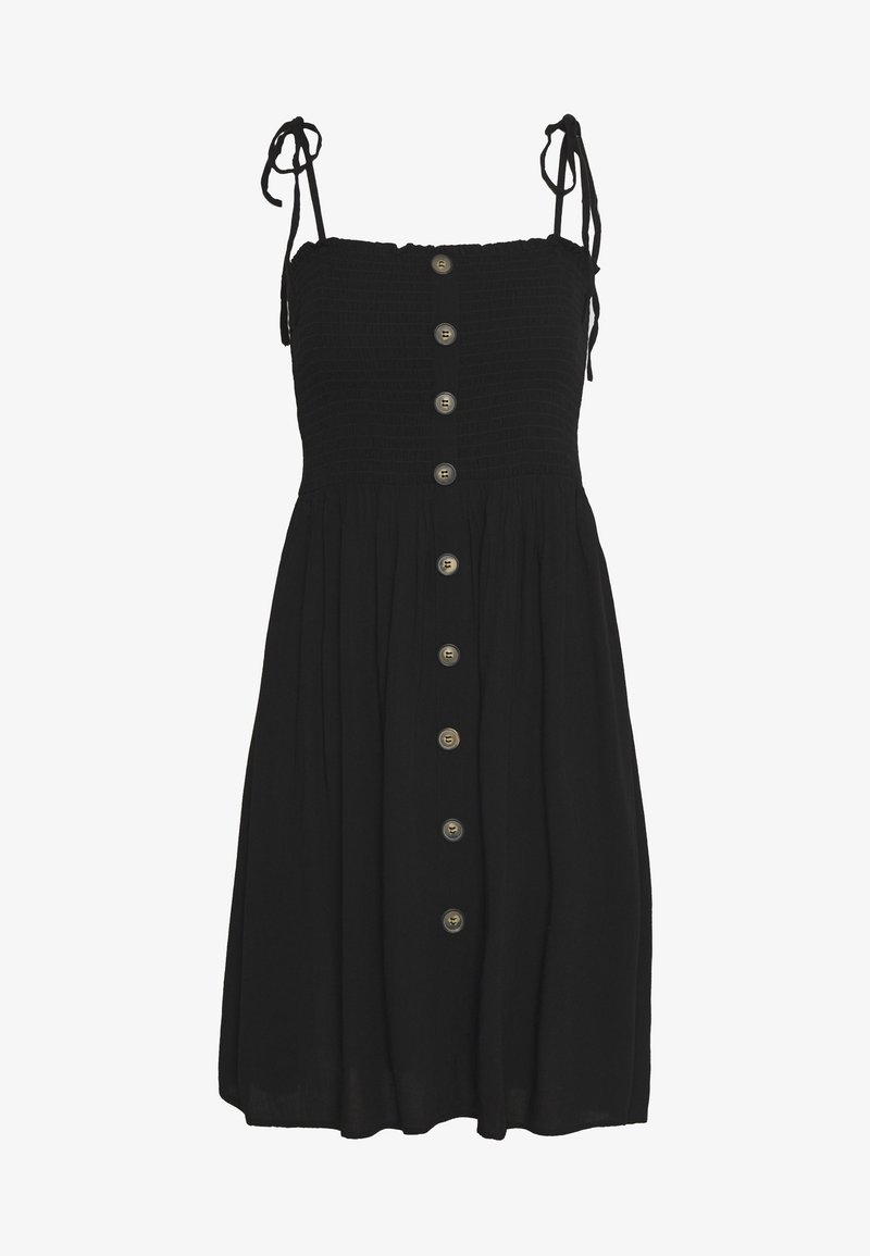 Robe noire avec un corsage smocké ajusté et des bretelles réglables. Présente une jupe ample et six boutons métalliques sur le devant.