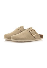 Zuecos de ante beige con punta redonda y una hebilla decorativa dorada. Suela acentuada con corcho y un dibujo texturizado para mayor agarre.