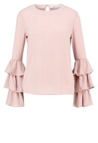 Blusa rosa tenue realizzata in tessuto leggero, con maniche lunghe dotate di tre volant svasati sui polsini e con scollatura rotonda.