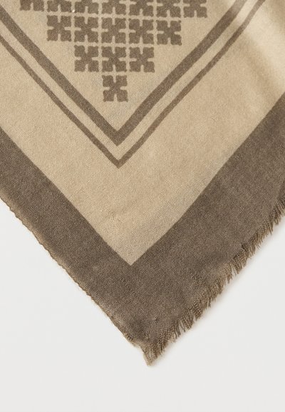 Coin de tissu tissé beige et marron avec motif croix géométrique et bord effiloché sur fond blanc.