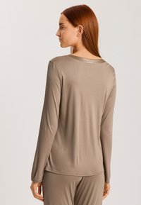 Långärmad, lätt topp i en mjuk taupe-färg, med rundad halsringning och slät textur. Enkel, elegant design utan dekorationer.