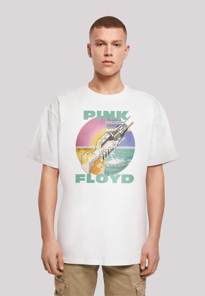Weißes Baumwoll-T-Shirt mit einem grafischen Design, das eine stilisierte Waffe, Wellen und einen Sonnenuntergang zeigt. Der Text lautet "PINK FLOYD" in Grün. Kurze Ärmel.