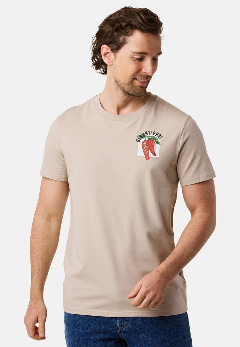 Beige bomulls t-shirt med rund hals, korta ärmar och en färgglad chilipeppar grafisk design på bröstet. Slät textur, avslappnad passform.