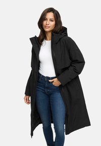 Black long parka with hood, zipper closure, and pockets; features a smooth texture and a relaxed fit, worn over a white top and blue jeans.
