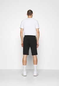 EA7 Emporio Armani BERMUDA - Pantalones deportivos - black/gold-coloured
