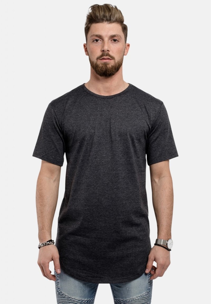 Korte mouwen, t-shirt met ronde hals in donkergrijze stof met een gladde textuur, iets verlengd zoom, gecombineerd met lichtblauwe distressed jeans.