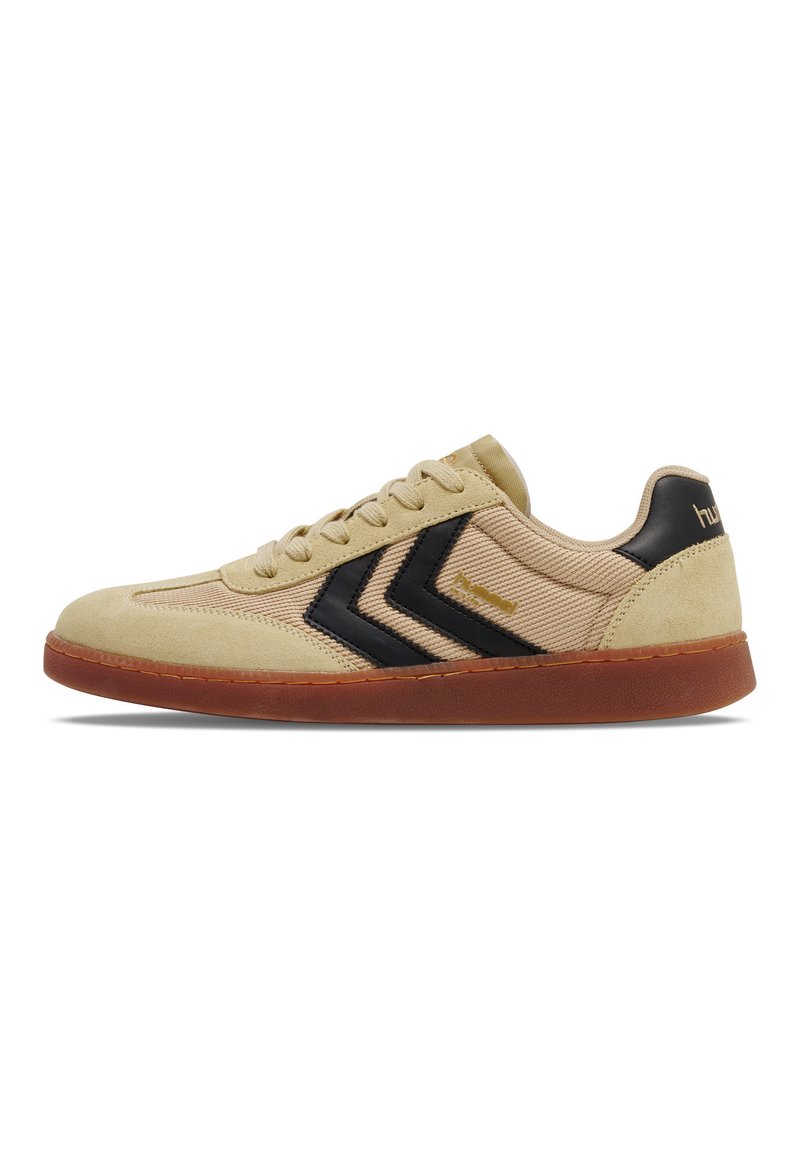 Sneaker beige in suede e tessuto strutturato, con dettagli a chevron neri, lacci e suola in gomma naturale. Logo discreto sul tallone.