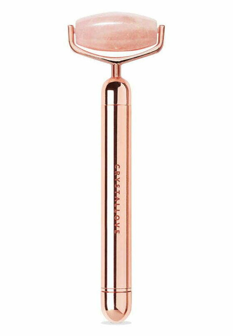 Różowy kwarcowy roller do twarzy z zaokrągloną głowicą kamienną i metalowym uchwytem w kolorze różowego złota. Napis na uchwycie brzmi "CRYSTALLOVE".