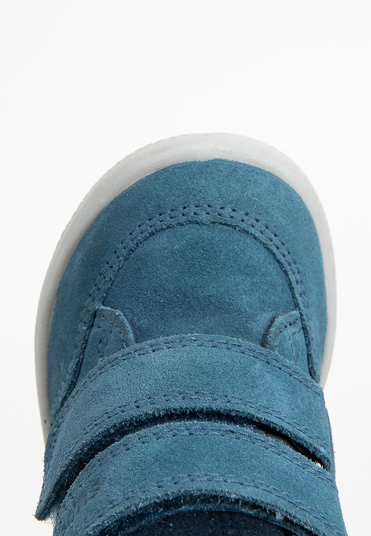Blaue Wildlederschuhe für Kleinkinder mit zwei Klettverschlussriemen und einer weißen Gummisohle, von oben gezeigt.