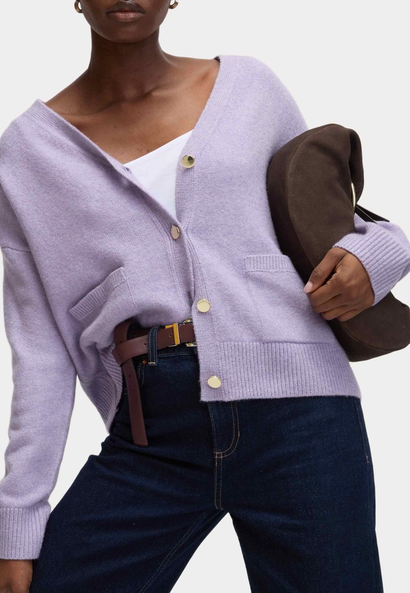 Cardigan lilla chiaro in tessuto morbido, con scollo a V, bottoni dorati, due tasche, polsini a coste e vestibilità comoda.